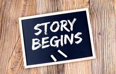 STORY BEGINS text on chalkboard on the wooden background