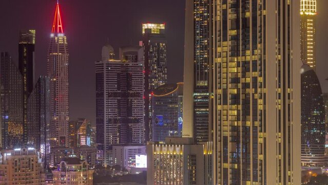 Row of the tall buildings around Sheikh Zayed Road and DIFC district aerial day to night transition timelapse in Dubai, UAE. International Financial Centre skyscrapers with glass surface