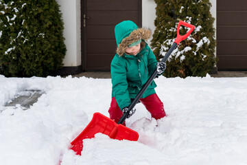 Winter kids fun outdoor sports. Girl clearing sidewalks and shoveling snow. Child removaling snow...