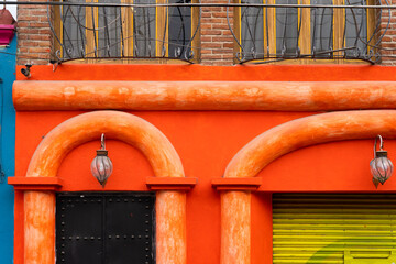 Bright orange building facade with lamps. Traditional Mexican colorful architecture concept