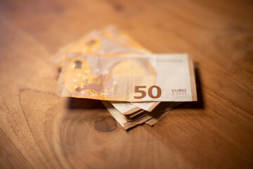liasse d'argent liquide posée sur une table en bois. Billets de banque de 5O euros. Image pouvant...