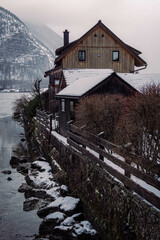 Typical alpine style buildings in Hallstatt, Austria during a snowy winter afternoon.