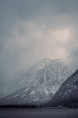 Mountain range with strong atmosphere during a snowy, dark winter afternoon