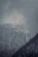Mountain range with strong atmosphere during a snowy, dark winter afternoon