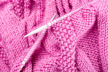 Background with knitting pink wool sweater in progress. top view. Knit a Braid Cable
