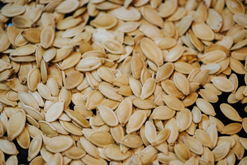Scattered across the baking sheet roasted pumpkin seeds in shell