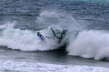 Surfing on high waves on the Mediterranean Sea in northern Israel.
