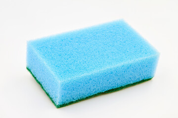 Blue foam cleaning sponge for washing dishes, cleaning the bathroom and other household needs on a white background. Closeup