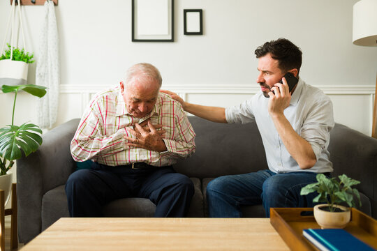 Concerned son calling emergency 911 due to a heart attack of his elderly father