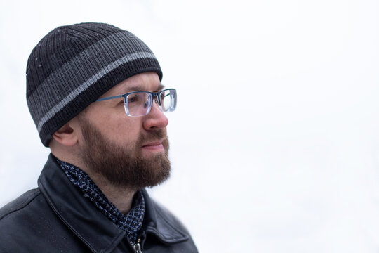 Portrait Of Adult Thinking Serious Man With Beard And Glasses In Warm Winter Clothes Black Color On The White Background