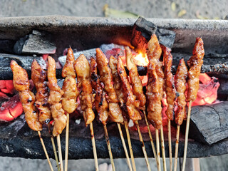 Chicken satay over coals
