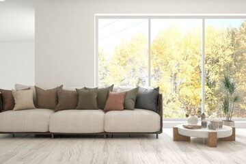 Fototapeta premium Stylish room in white color with sofa and autumn landscape in window. Scandinavian interior design. 3D illustration