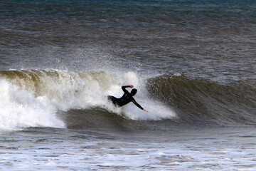 Surfing on high waves on the Mediterranean Sea in northern Israel.