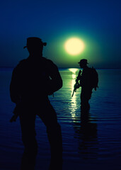 Army soldiers with rifles moon night silhouette in action during raid crossing river in the water, two militants with rifles at night