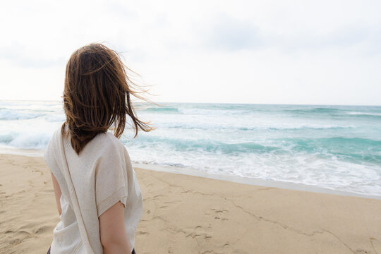 The Back View Of Woman Staring The Horizon Over The Ocean
海に広がる地平線を見つめる女性の後ろ姿