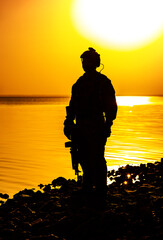 Army soldier with rifle orange sunset silhouette