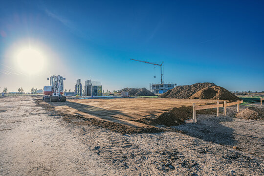 Minnibagger auf Baustelle mit Baukran