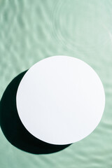 White circle copy space in transparent fresh green blue water drop splashing gel surface with flecks, waves, shade. Health care relaxation. Sea natural concept. Flat lay. Place for text. Vertical