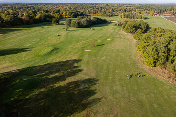 Aerial view of a big golf course, beautiful green grass, field and trees in autumn