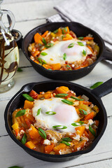Shakshouka in frying pan. Fried eggs with vegetables, tomato, pepper, pumpkin and onion