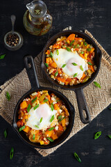 Shakshouka in frying pan. Fried eggs with vegetables, tomato, pepper, pumpkin and onion. Top view