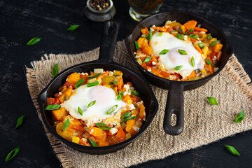 Shakshouka in frying pan. Fried eggs with vegetables, tomato, pepper, pumpkin and onion