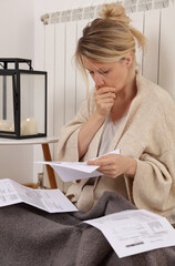 Worried woman holding bills for electricity, gas and heating. Global energy , saving concept