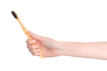 A hand holds a bamboo toothbrush isolated on white. Holds a wooden eco toothbrush. Oral care....