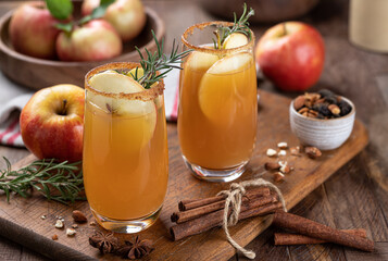 Apple cider cocktail with sliced apples and rosemary