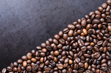 Coffee beans on dark background, diagonal order aligned close-up still life with copy space for text