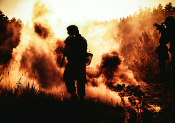 United States Marines in action. Military action, desert battlefield, smoke grenades., fire and explosions. Sun setting, dark silhouette in the desert