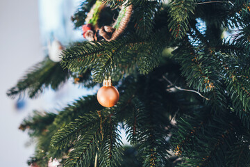 Close-up of Christmas bauble decoration ornament globe on the background of the Christmas tree. Gifts and congratulations holidays concept, xmas, snow