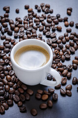 Coffee beans and cup on dark background, close-up still life