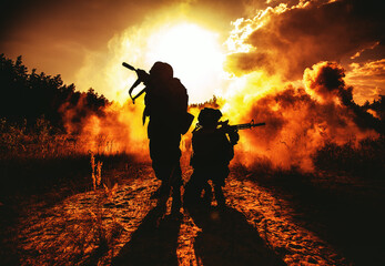 United States Marines in action. Military action, desert battlefield, smoke grenades., fire and explosions. Sun setting, dark silhouettes in the desert