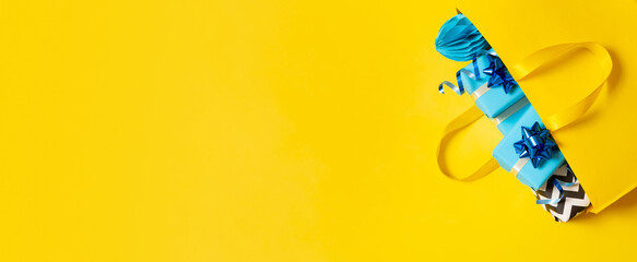 Banner with gift boxes in shopping bag. Holidays shopping concept flat lay, top view. Copy space