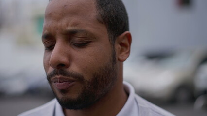 One anxious young African American man in distress closeup face. Portrait of a black person with worried preoccupied emotion