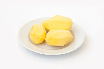 Peeled potatoes on a plate on a white background