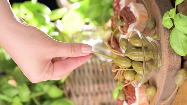 Capers. Marinated capers in a bowl . Large capers with a sprig. Aperitif in Italy. vertical video. High quality 4k footage