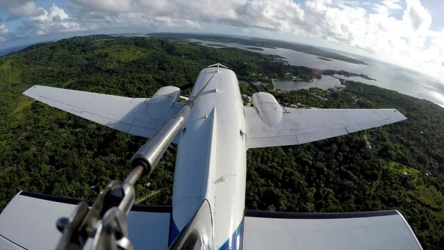 External perspective of twin engine plane flying over ocean