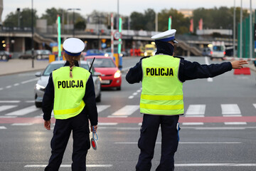 Policjantka z lizakiem do zatrzymywania pojazdów kontroluje ruch drogowy.  - obrazy, fototapety, plakaty