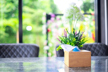 White tissue paper with tissue box on the wooden table in restaurant at breakfast time and nature blure background