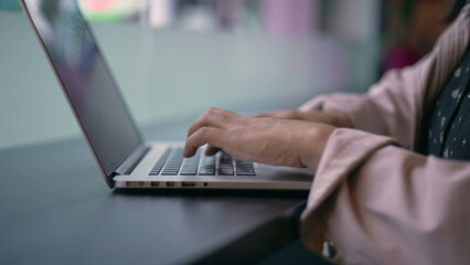 One young hispanic woman opening laptop in coffee shop remote workplace. South American Brazilian girl using computer typing in keyboard