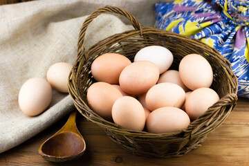Close-up view of basket full of eggs on wooden background
