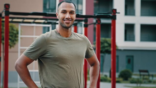 Handsome latino sportsman athletic ethnic man sport trainer doing welcome gesture inviting to join team advertisement of active healthy lifestyle health motivation to training on city sports ground