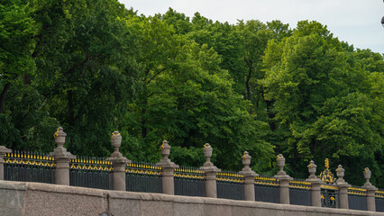 Decorative fence enclosing the Summer Garden, St. Petersburg, Russia. Park trees behind a granite fence