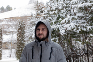 Fototapeta na wymiar portrait of a man walking in the woods in winter in snowy weather