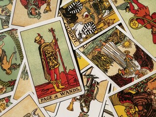 Cork, Ireland - 19 September 2022: Picture of the Page of Wands tarot card from the original Rider Waite tarot deck with mixed tarot cards in the background
