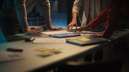 Close Up on Colleagues Discussing a New Business Opportunity, Putting Hands on a Meeting Room Table in an Office at Night. Discussing Project Plan on Tablet Computer with Development Timeline - Powered by Adobe