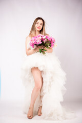 Beautiful young woman with delicate peony flower.