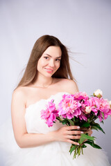 Beautiful young woman with delicate peony flower.